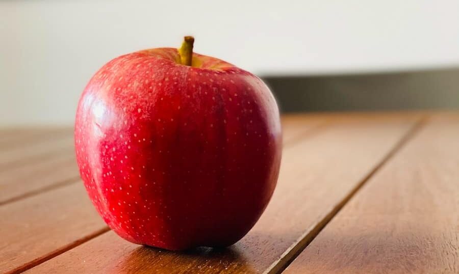 red apple fruit on brown wooden table